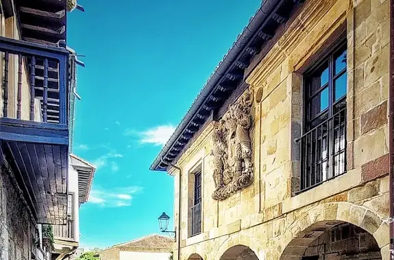 Casa de los Hombrones en la calle del Cantón de Santillana del Mar, con su soportal de arcos y el escudo de los Villa