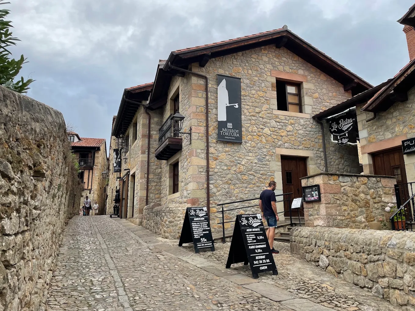 Calle empedrada de Santillana del Mar con la fachada del Museo de la Tortura al fondo