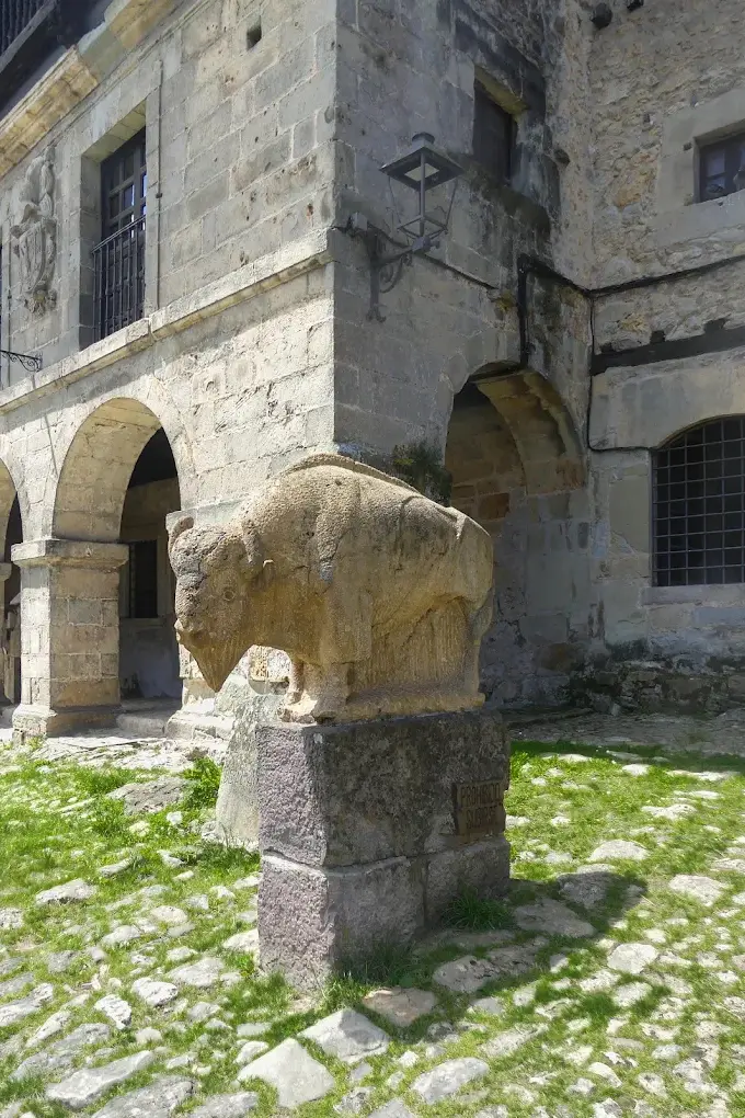 El Bisonte de Jesús Otero junto a los soportales de piedra de la Plaza Mayor de Santillana del Mar