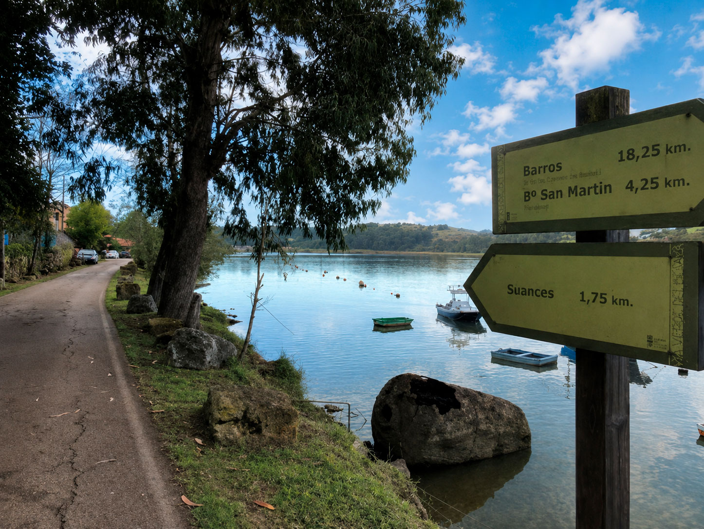 Senda junto a la ría en Los Cantos con poste de señalización hacia Suances, San Martín y Barros