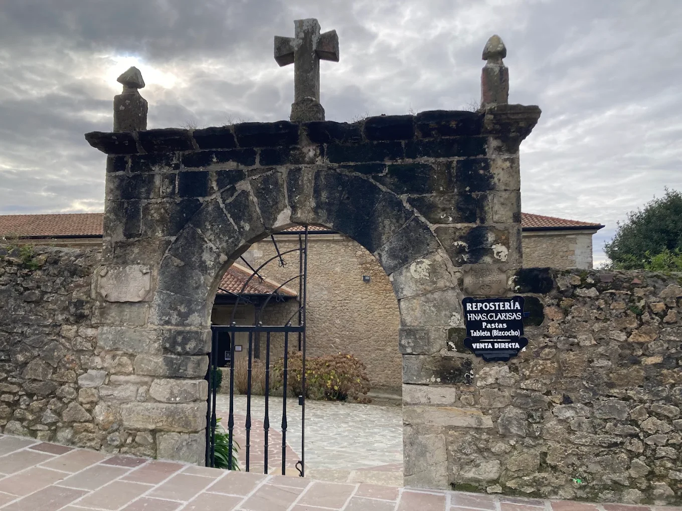 Puerta de acceso al Convento de San Ildefonso con el cartel de venta directa de la repostería de las Clarisas