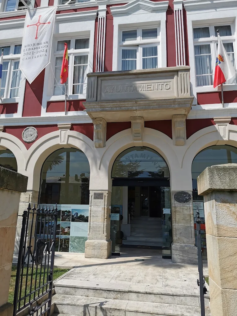 Detalle del balcón central del Ayuntamiento de Suances con la inscripción «Ayuntamiento» y las banderas de Cantabria y España