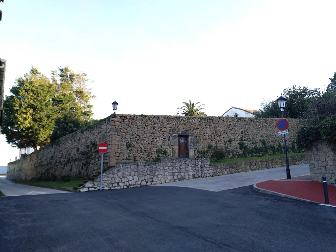 Muro perimetral de piedra de la Casa de los Polanco visto desde la calle, con una pequeña puerta de acceso secundaria