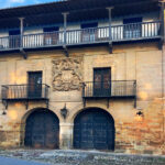 Casona de los Tagle o Casa de Sánchez Tagle Fachada principal de la Casona de los Tagle en Santillana del Mar, con dos arcos de acceso, balcones de forja y el gran escudo cuartelado bajo la galería