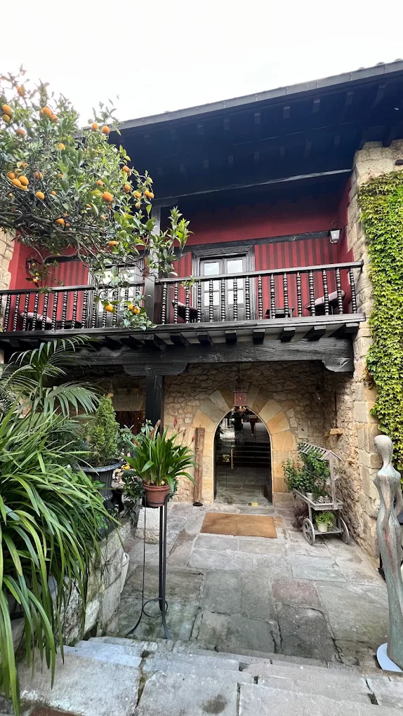 Fachada posterior de la Casa de Leonor de la Vega en Santillana del Mar, con soportal, arco apuntado y jardín
