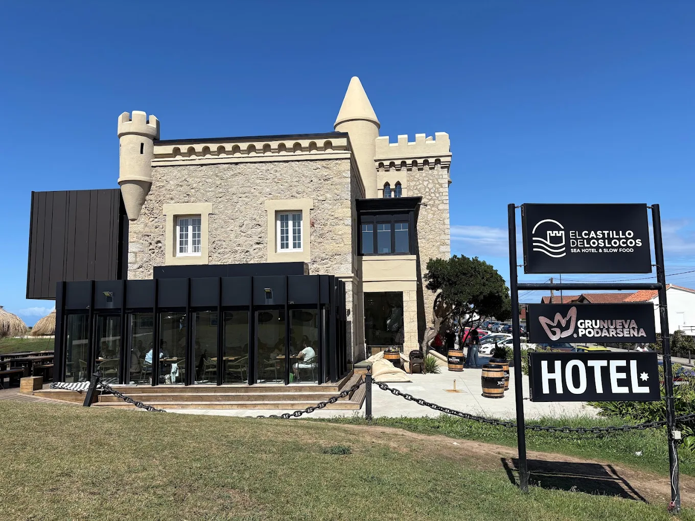 Fachada actual del castillo de Ceruti con el cartel de El Castillo de los Locos y la ampliación acristalada del restaurante