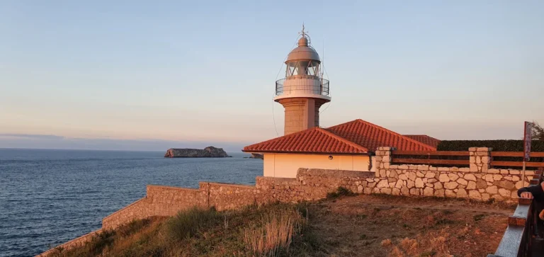 Faro de Suances al atardecer con la vivienda del torrero y un islote al fondo