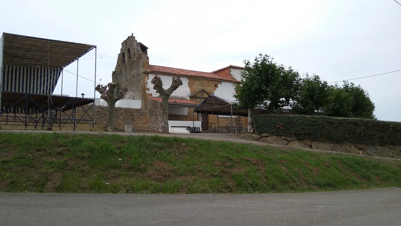 Fachada lateral de la iglesia de San Andrés de Puente Avíos con la cabecera poligonal y el entorno rural