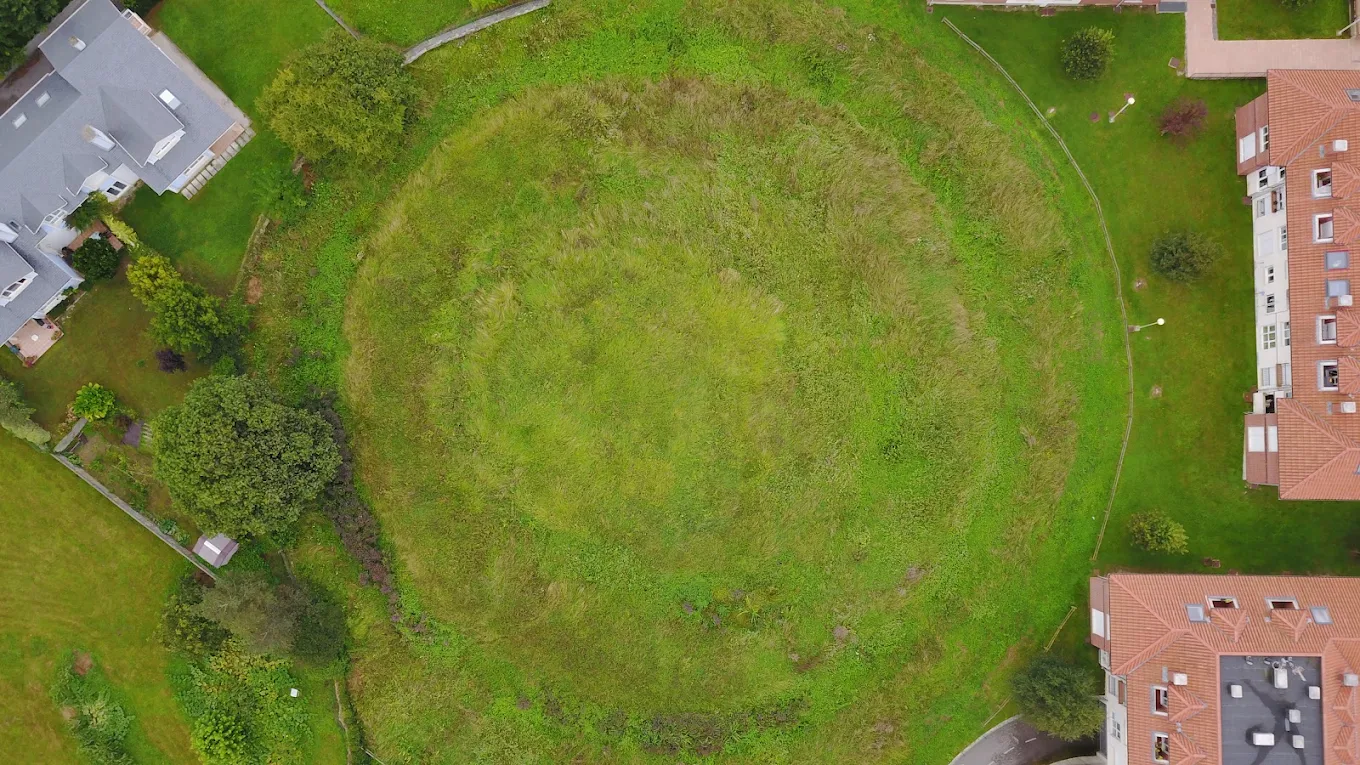 Vista aérea cenital de la Mota de Trespalacios en Hinojedo, con la geometría circular de fosos y murallas terreras vista desde arriba