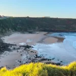 Vista panorámica de la playa de Los Locos desde el mirador superior, con el Castillo de Ceruti al fondo