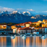 Vista panorámica de San Vicente de la Barquera desde la ría, con el Castillo del Rey, la iglesia de Santa María de los Ángeles y los Picos de Europa nevados al fondo