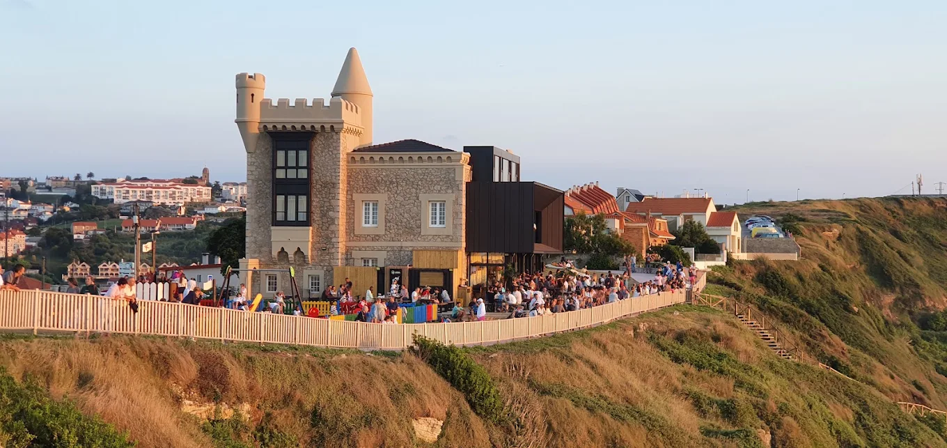 Castillo de Ceruti en Suances al atardecer con visitantes en la terraza exterior