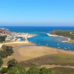 Panorámica soleada desde el Mirador de la Cuba de la desembocadura, el puerto y las playas de Suances