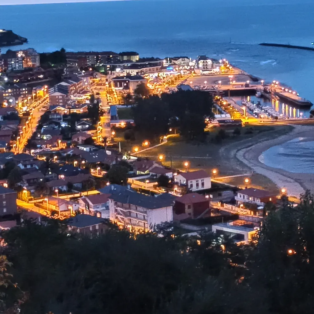 Vista nocturna desde el Mirador de la Cuba del pueblo, el puerto y la playa de Suances iluminados