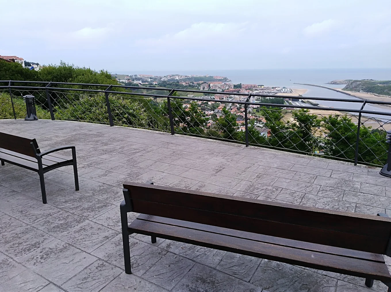 Terraza mirador con bancos junto a la bajada de la Fuente de Enmedio, con vistas al pueblo y la ría de Suances