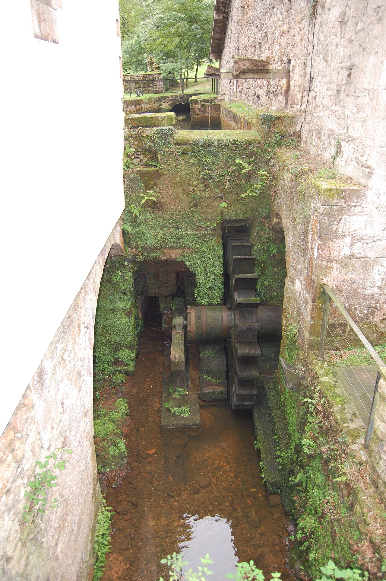 Rueda y canal de agua del molino de la antigua ferrería de Cades