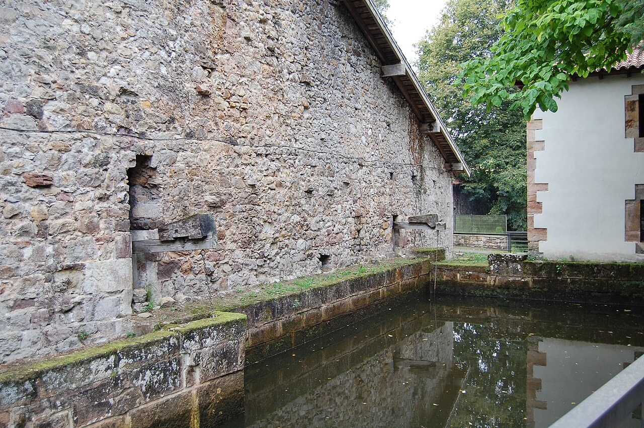 Edificio de la antigua ferrería de Cades junto al sistema hidráulico