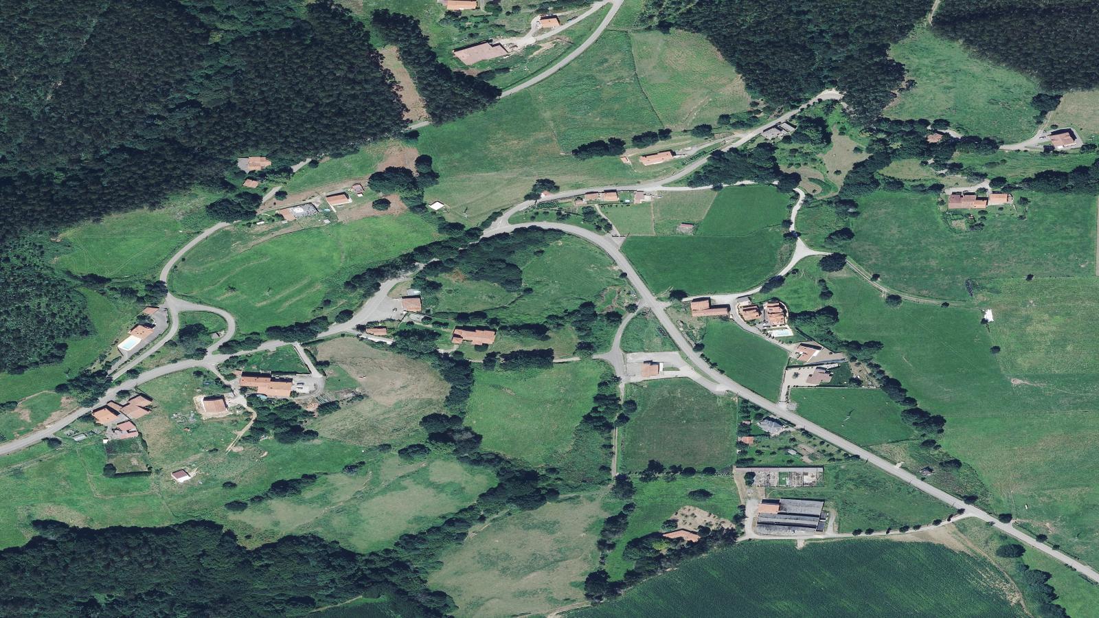 Vista aérea de Las Pilas y su entorno de prados y arbolado, en Ribamontán al Monte