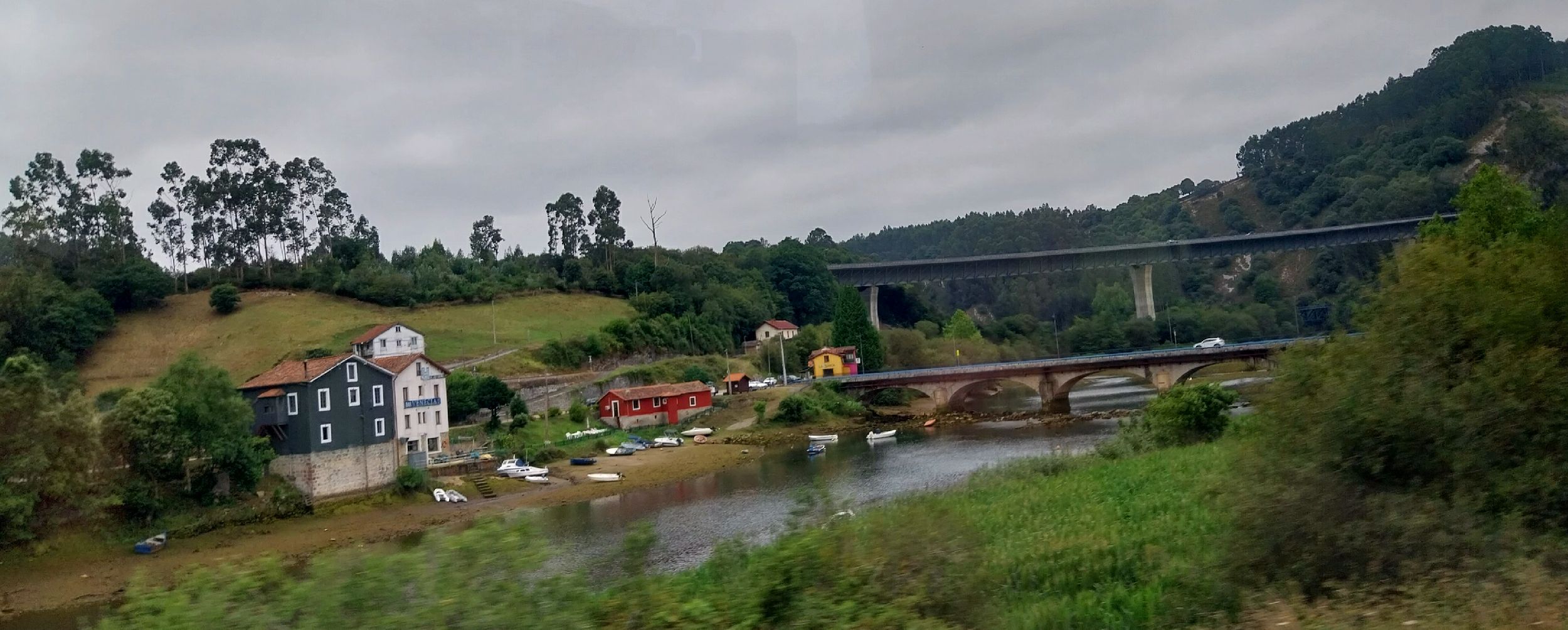 Vista de Pesués junto a la ría de Tina Menor, con sus puentes y casas